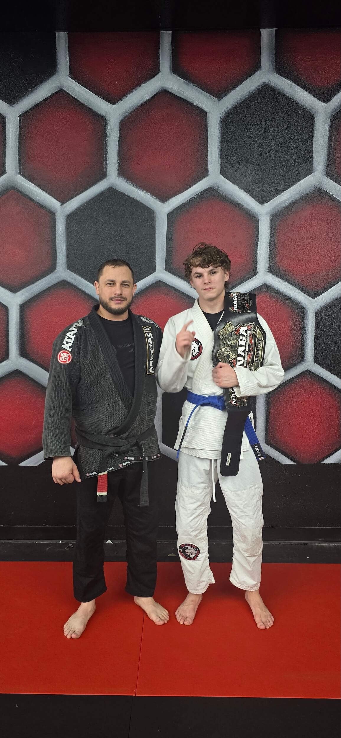 Martial Arts of Waco student smiling with instructor holding winners martial arts belt.